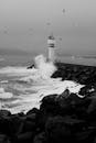 阴沉的天空下，强大的海浪撞击着灯塔，捕捉着大自然的力量