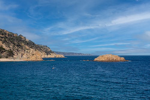 View of a Rocky Coastline and Blue Water under Blue Sky 