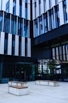 Striking modern architecture featuring a sleek glass and metal facade in a daytime urban setting.