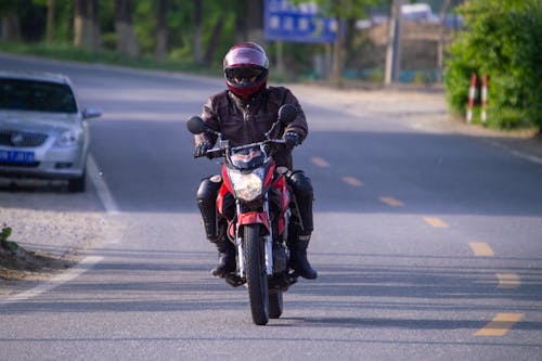 Man Riding a Motorcycle on the Street 