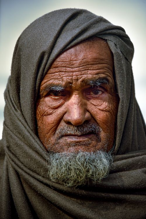 Free Close-up portrait of an elderly man with a headscarf and gray beard, conveying deep emotion. Stock Photo