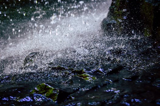 苔藓岩石上水花飞溅的动态特写，捕捉自然的能量