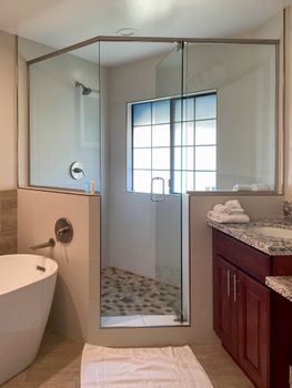 Elegant bathroom featuring a glass shower, bathtub, and granite countertop.