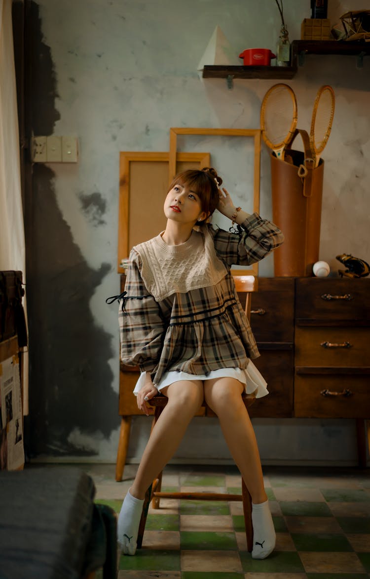 A Woman Looking Up While Sitting On A Chair