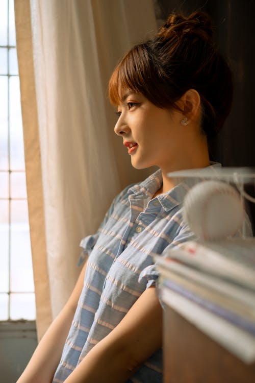 Free Woman in Blue and White Plaid Shirt Looking at the Window Stock Photo