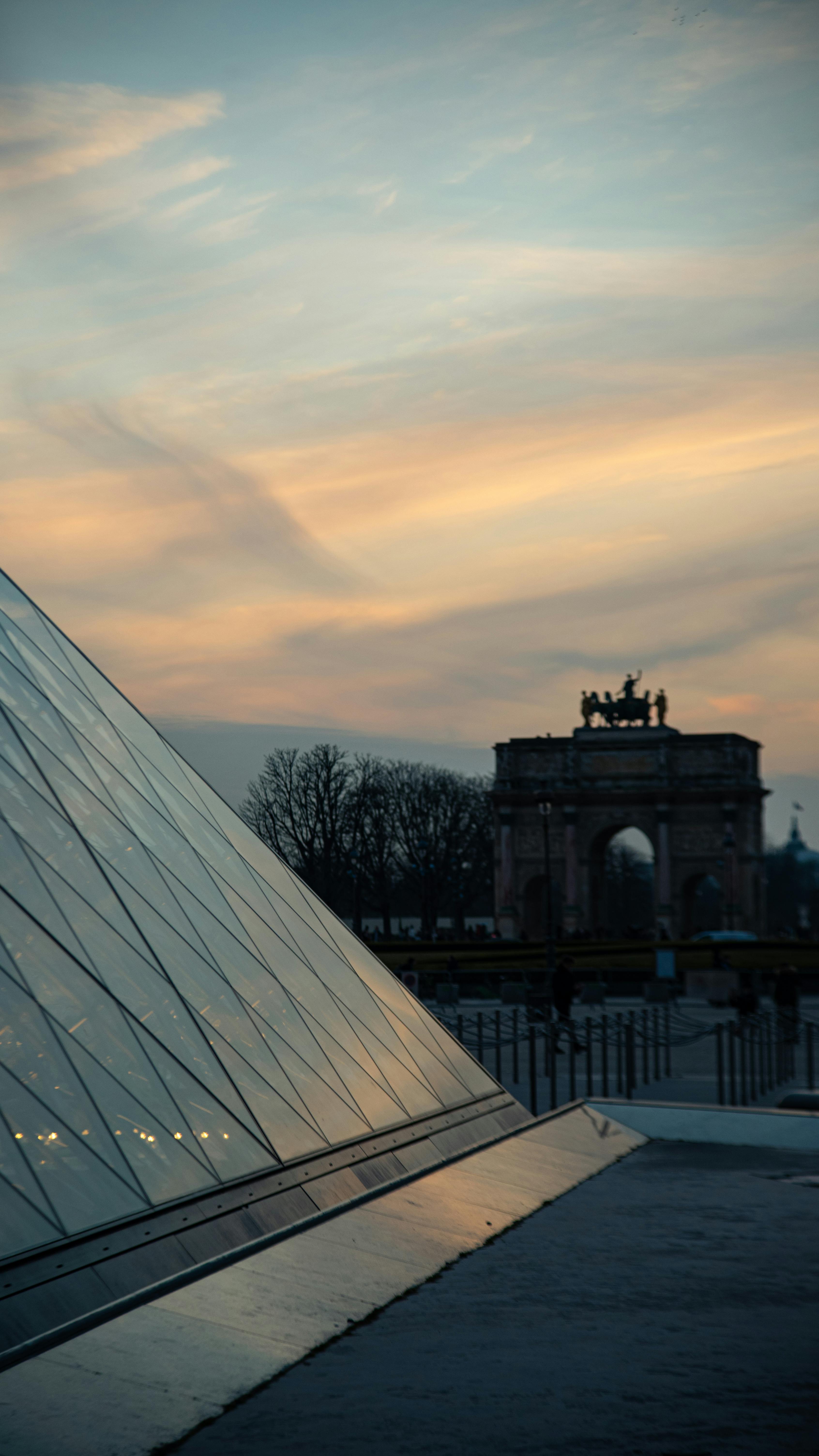 sky over the triumphal arch of the carousel and the louvre pyramid paris france