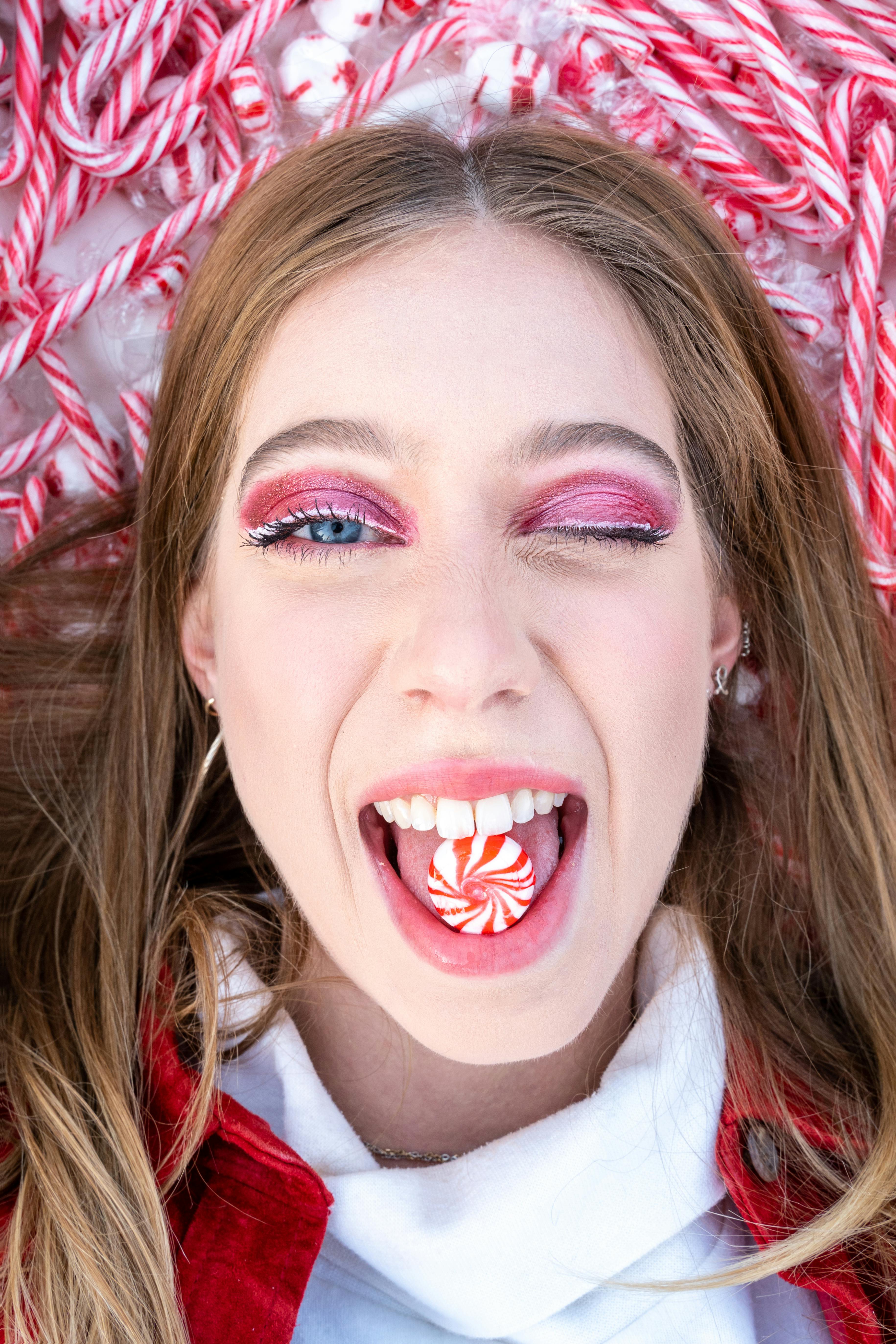 a woman eating candy while smiling at the camera