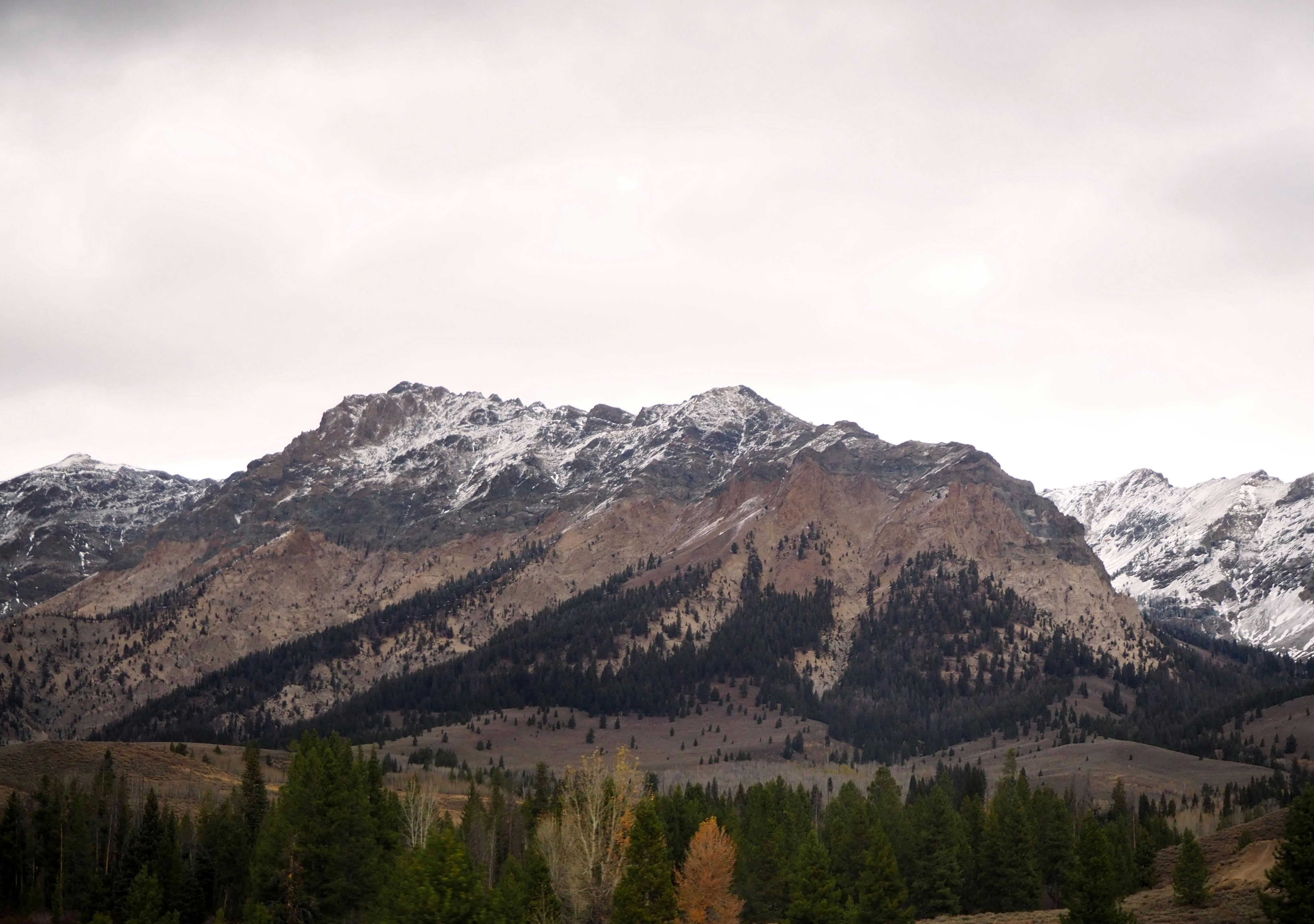 Captivating view of a rugged mountain range with snow-capped peaks under a gloomy sky.