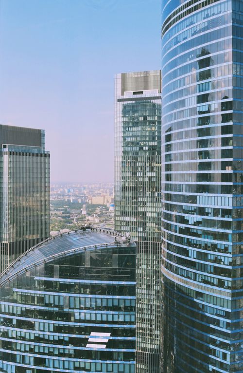 Free Vertical shot of modern glass skyscrapers in an urban cityscape during the day. Stock Photo