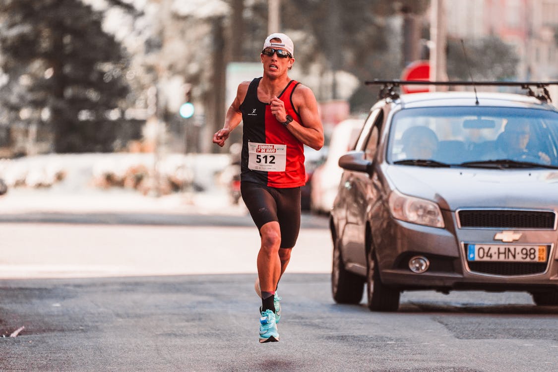 Free A focused male runner competes in an urban marathon, showcasing determination and athleticism. Stock Photo