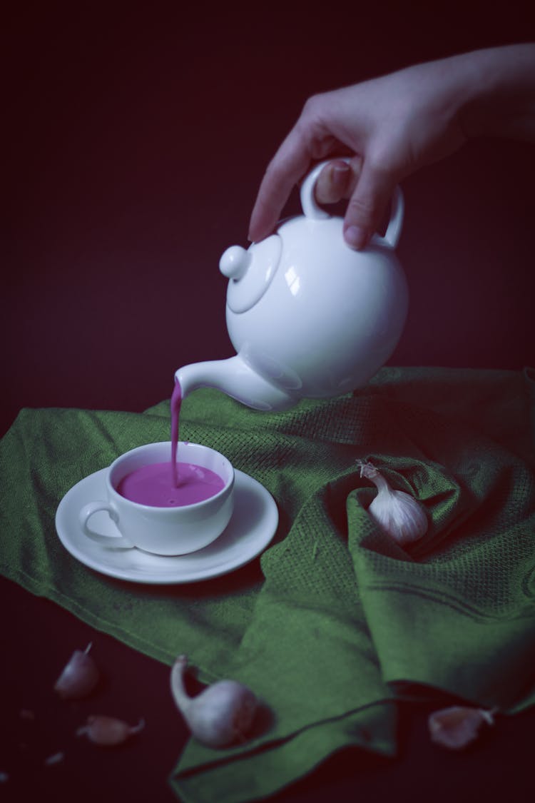 Pouring Purple Drink Into A Teacup