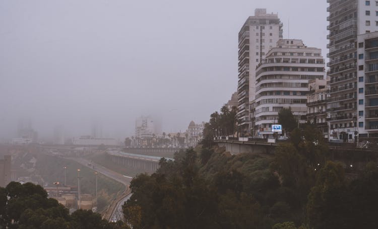 City Buildings On A Hill And Elevated Road In Mist