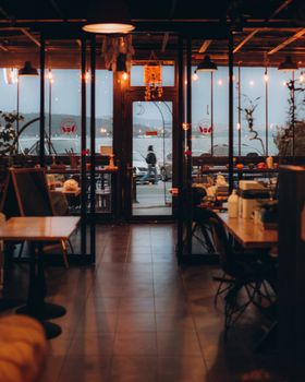 Warm and inviting restaurant interior overlooking the sea with ambient lighting.