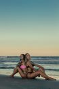 Two Attractive Women in Bikini Sitting on Sea Beach