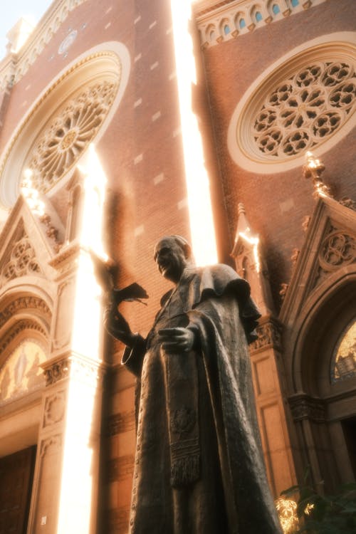 An image of a statue of the pope outside a church. 