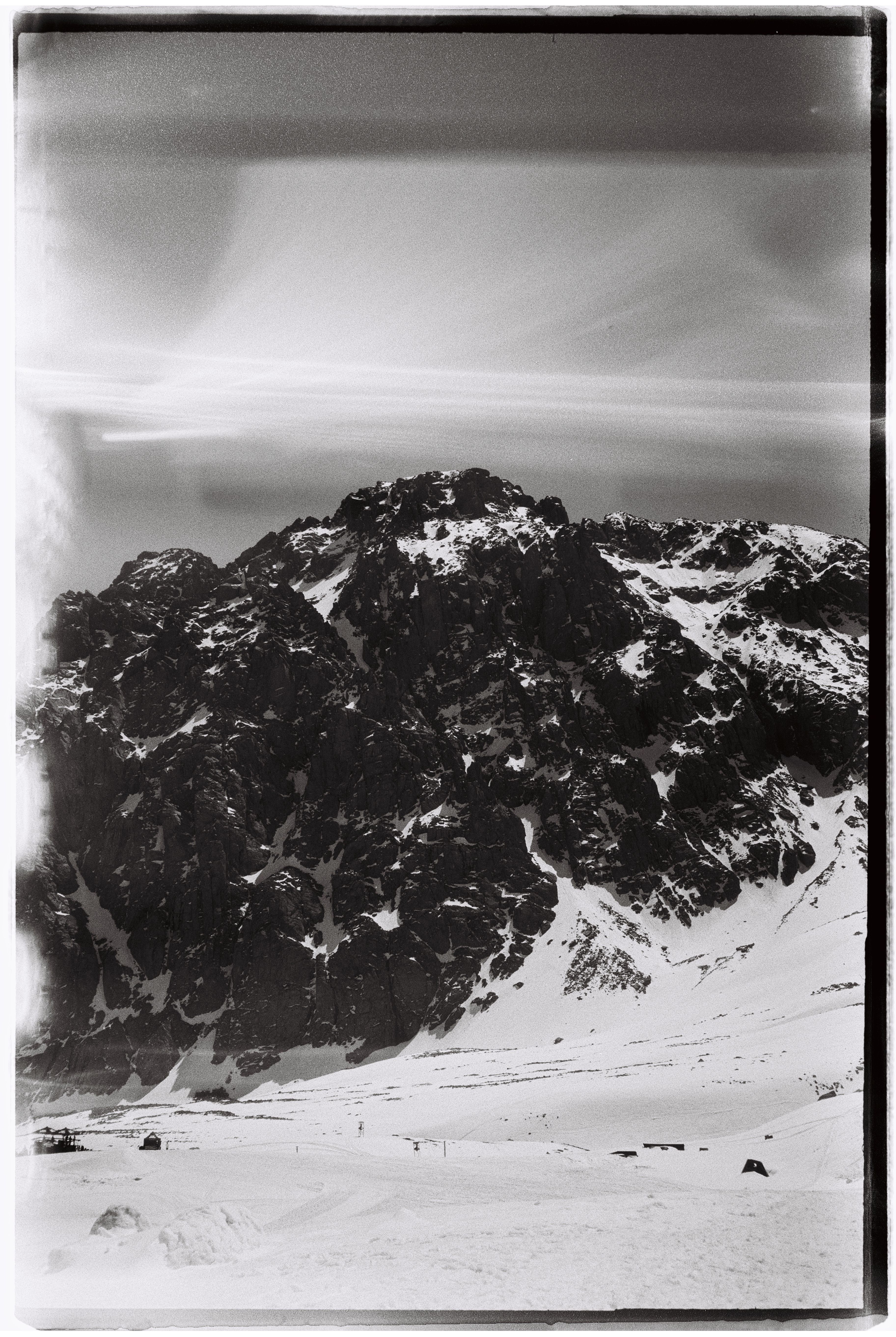 Explore the rugged snow-capped mountains of Almaty, captured in stunning black and white.