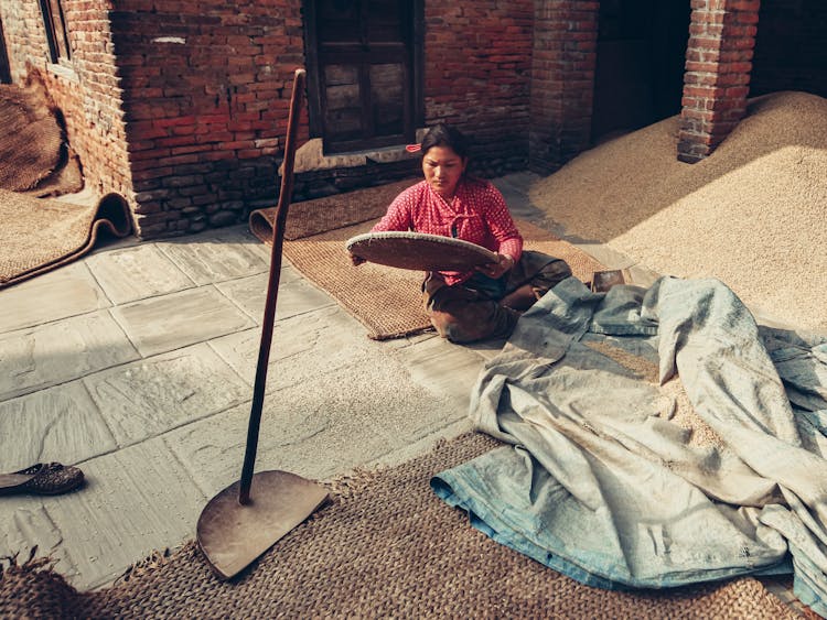 Woman Sieving Grain