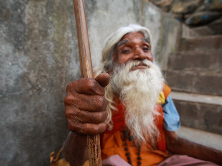 Elderly Man Holding A Brown Stick