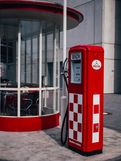 A Red Gasoline Pump Near Glass Windows