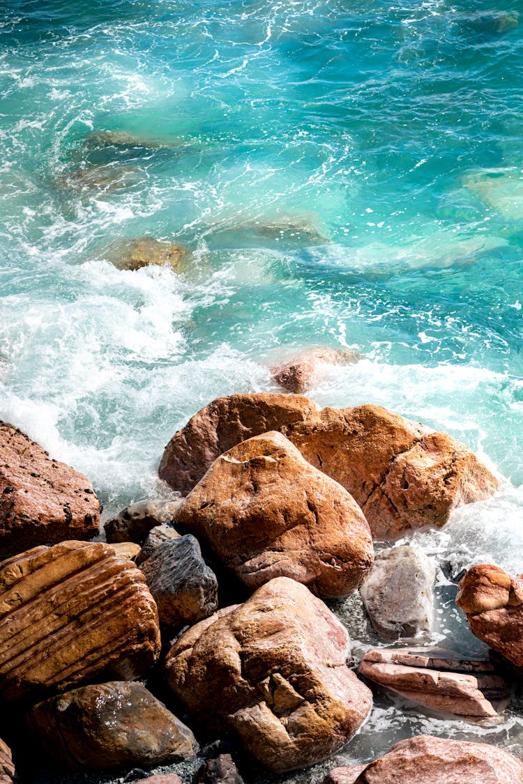 Waves Crashing On Brown Rocks