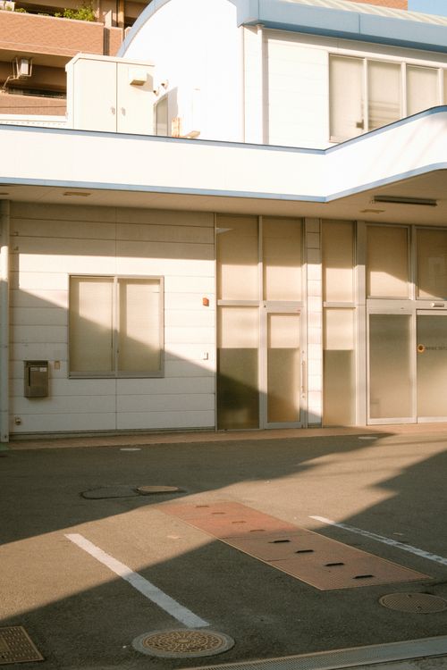 Free A modern white building exterior with glass windows and minimalist design elements. Stock Photo