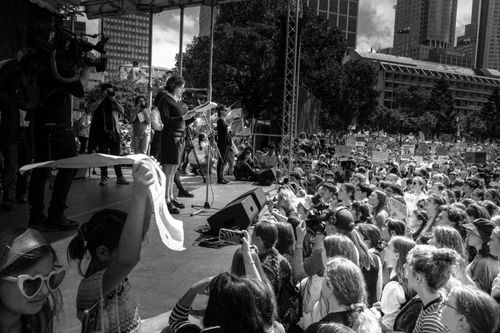 Free A large crowd at an outdoor gathering in Sydney, featuring a public speaker on stage. Stock Photo