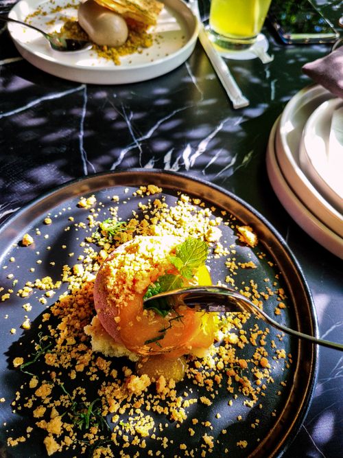 Free A beautifully plated gourmet dessert with crumble topping and fresh mint on a dark plate. Stock Photo