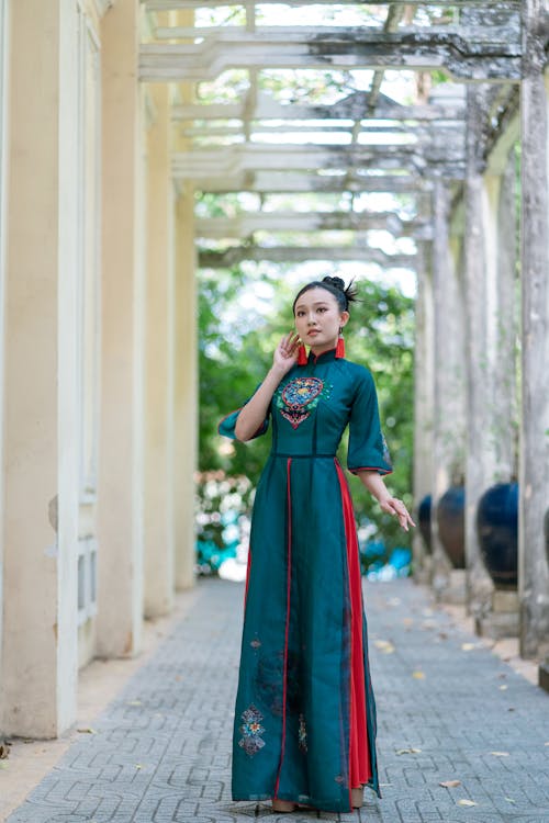Woman in Blue and Red Traditional Dress Standing on Walkway