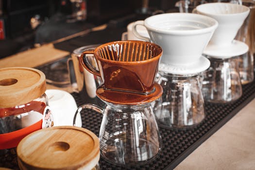 Array of ceramic and glass coffee drippers on display in a cozy coffee shop setting.