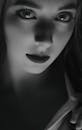 这幅迷人的黑白特写肖像描绘了一位眼神深邃、光影效果极具戏剧性的女性