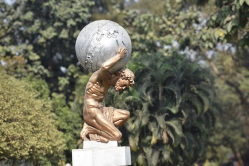 Free Man sculpture holding Earth Stock Photo