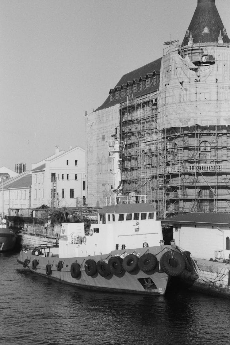 Tower Under Construction And A Ship Moored In A Canal 