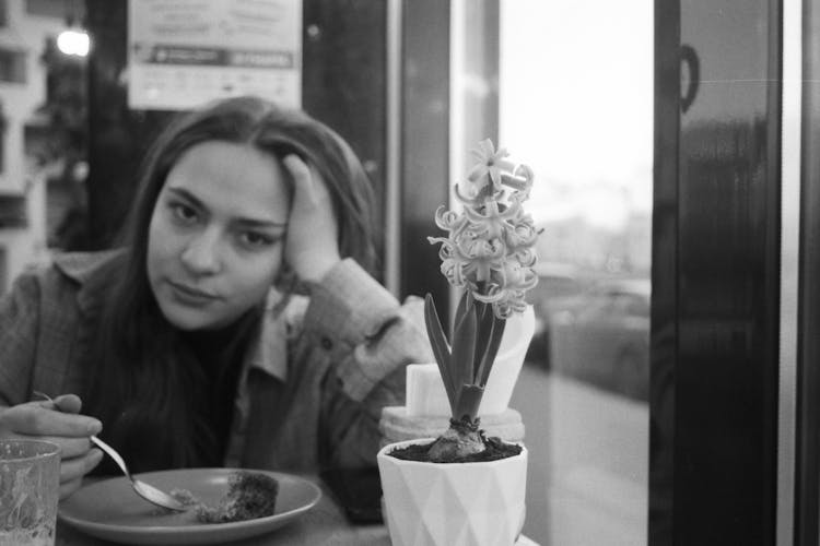 Tired Woman Eating Cake In Restaurant