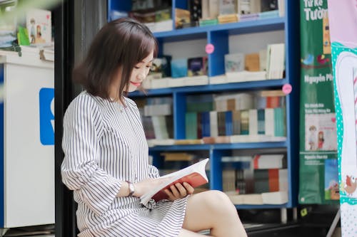 Woman Sitting While Reading A Book