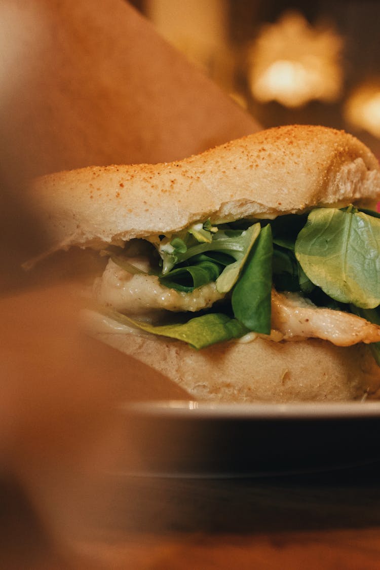 A Burger With Meat And Green Leaves