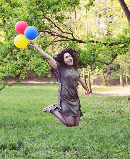 Gratis Wanita Melompat Sambil Memegang Empat Balon Foto Stok