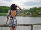 在罗马尼亚锡比乌，一位穿着时髦的女士站在风景秀丽的湖边，欣赏夏日美景