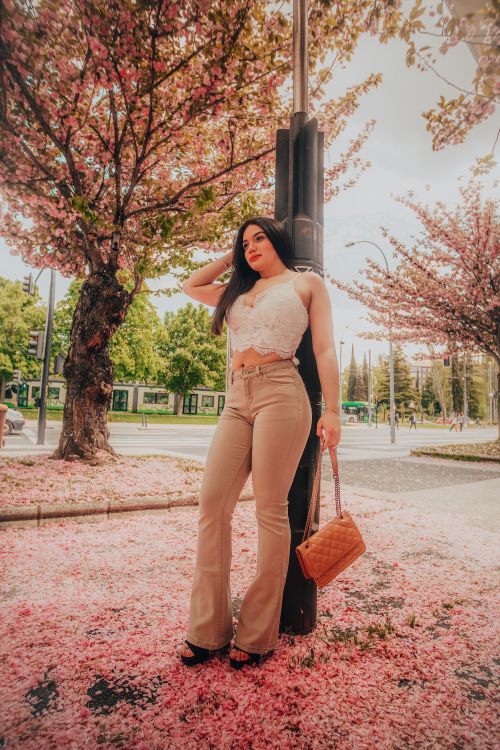 Free Charming spring portrait of a woman posing stylishly among blooming cherry blossoms in Vitoria-Gasteiz, Spain. Stock Photo