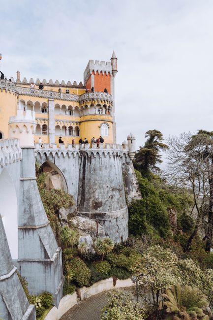 Breathtaking view of the colorful Pena Palace in Sintra, surrounded by lush greenery, a popular tourist landmark.