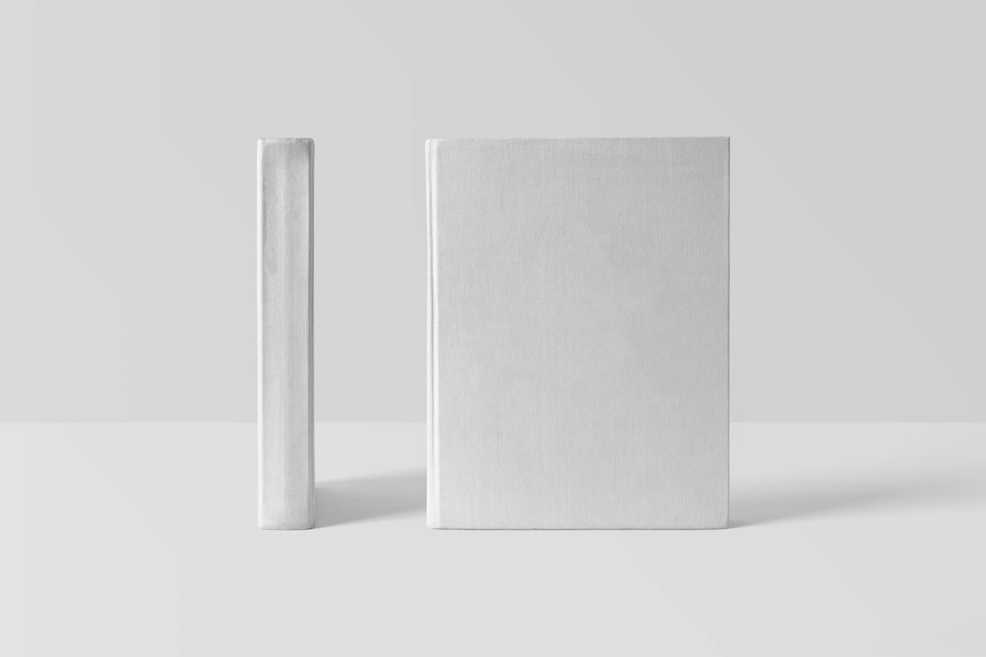 Two blank book covers on a white surface, ideal for mockup and design projects.
