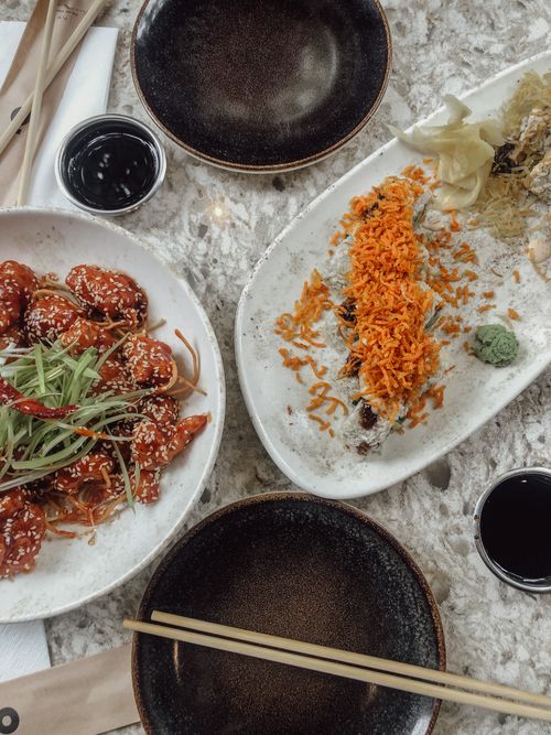 Free Flat lay of sushi and Asian dishes on marble, highlighting vibrant colors and textures. Stock Photo
