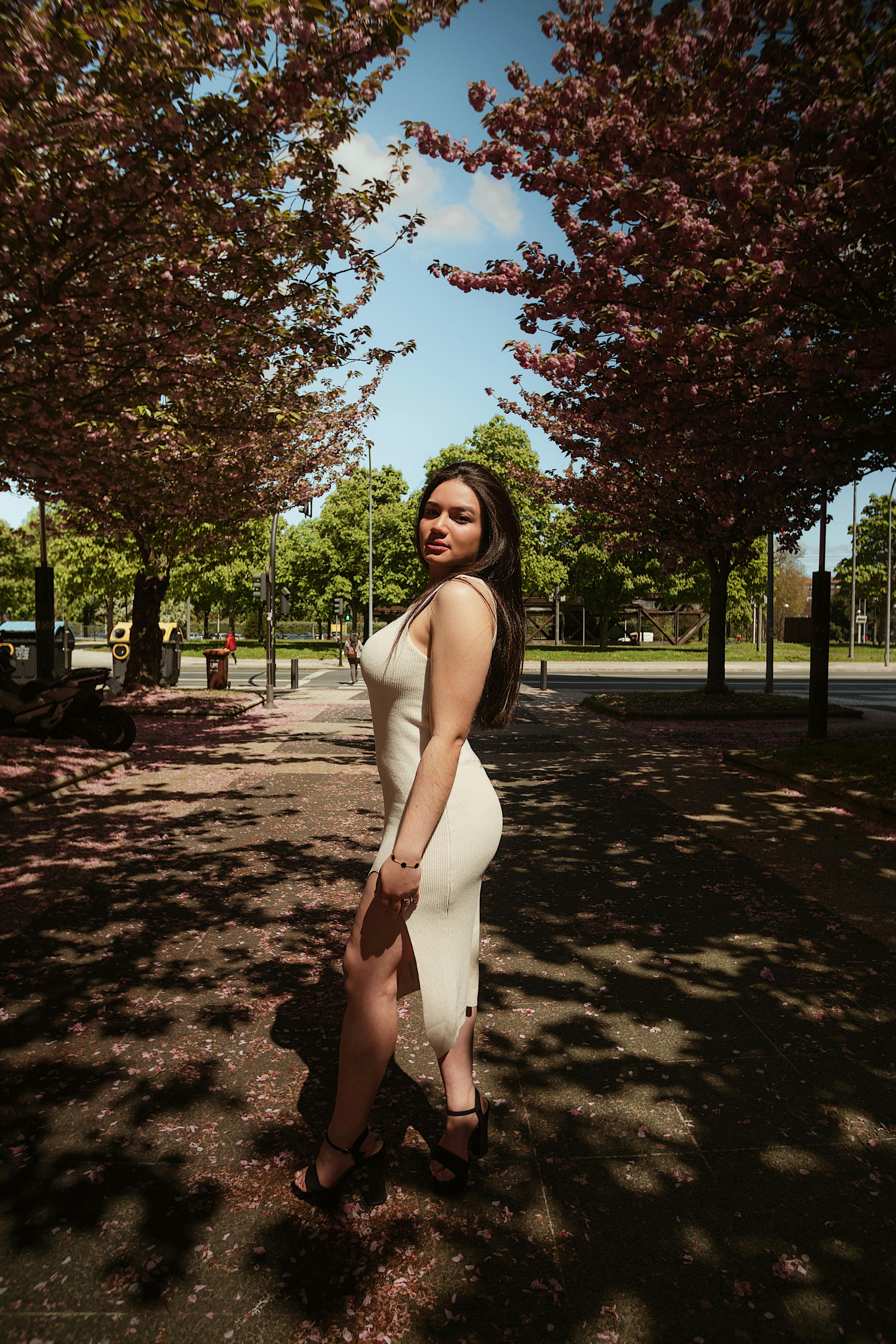 woman in white tank top and white pants standing on brown soil