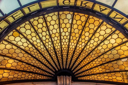Elegant stained glass window with geometric fan pattern and warm hues.. elegant, stained, glass