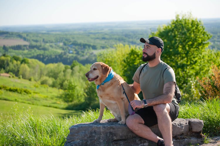 Man With Dog Relaxing In Countryside In Summer