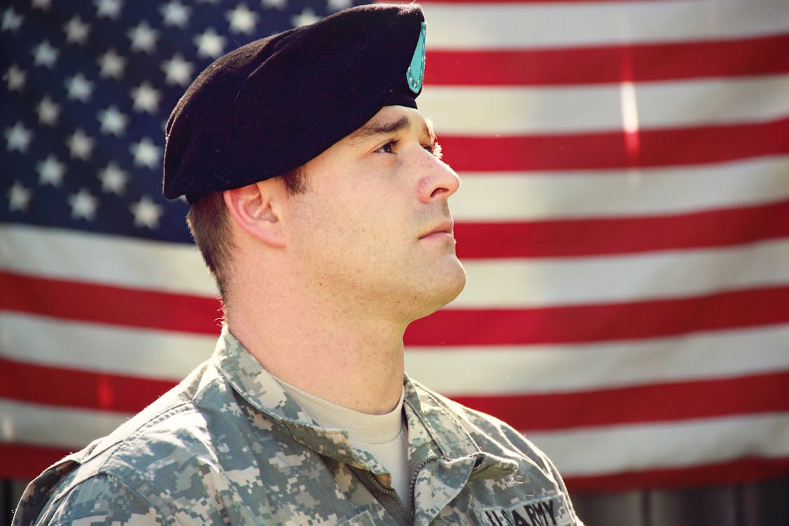 US military personnel with US flag in behind