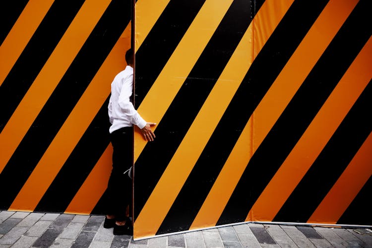 Man Opening A Door To The Striped Building