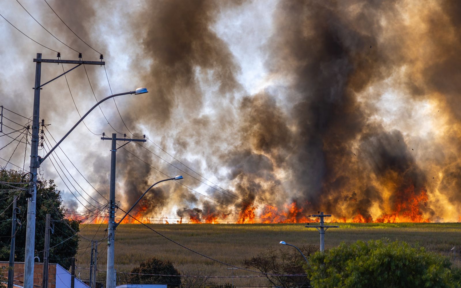 Rural landscape engulfed in flames and thick rising smoke