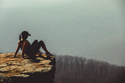 암석에 여자의 얕은 초점 사진