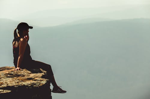 崖の上に座っている女性