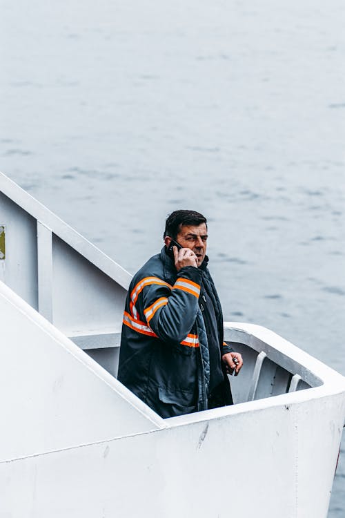 Ücretsiz adam, akıllı telefon kullanma, deniz içeren Ücretsiz stok fotoğraf Stok Fotoğraflar